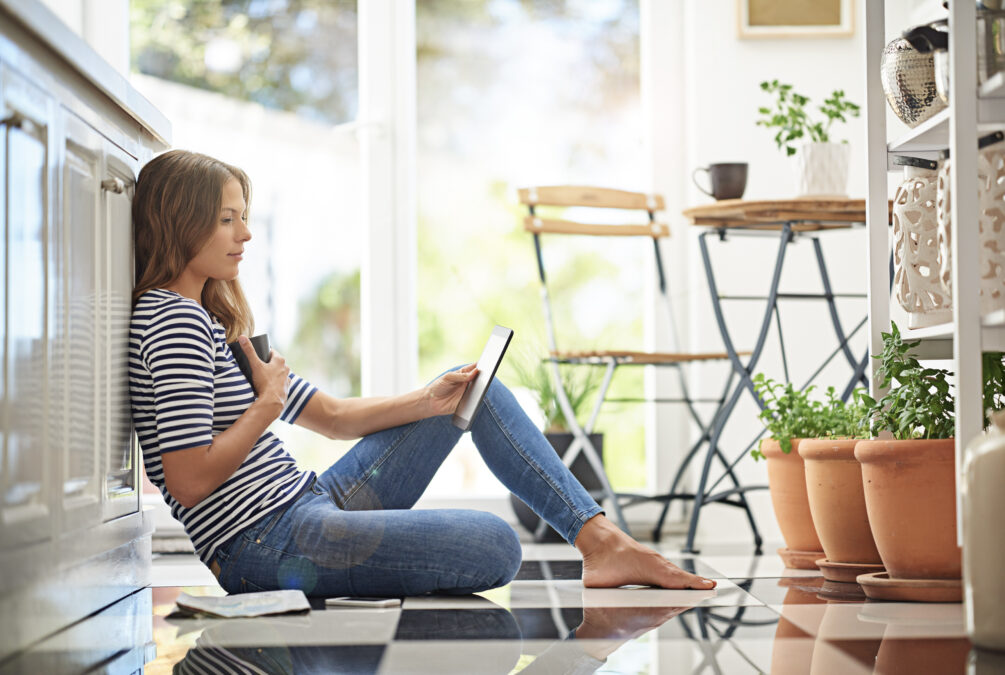 Woman sitting on floor looking at tablet
