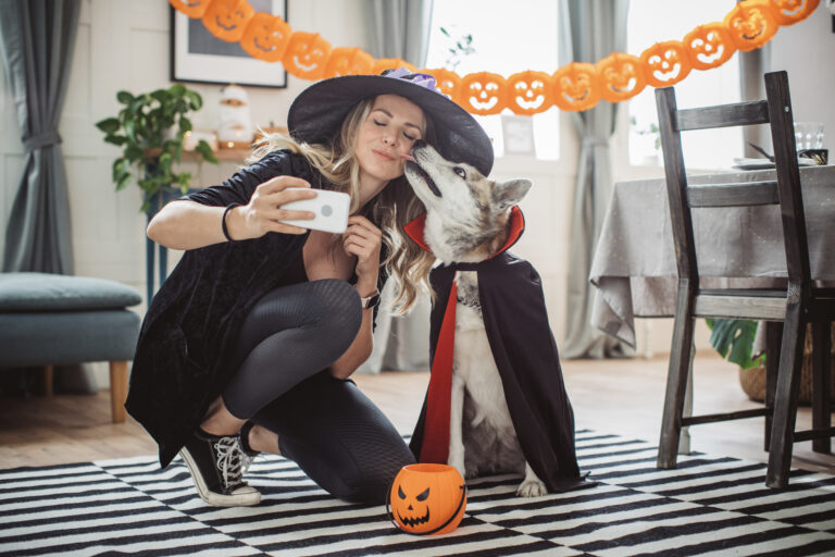 Woman and dog dressed in Halloween costumes taking a selfie photo