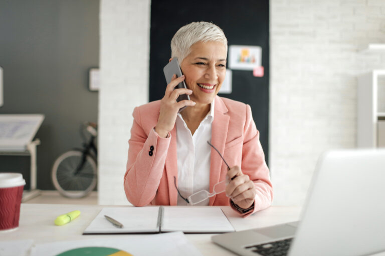 Mature woman talking on the phone in her office office