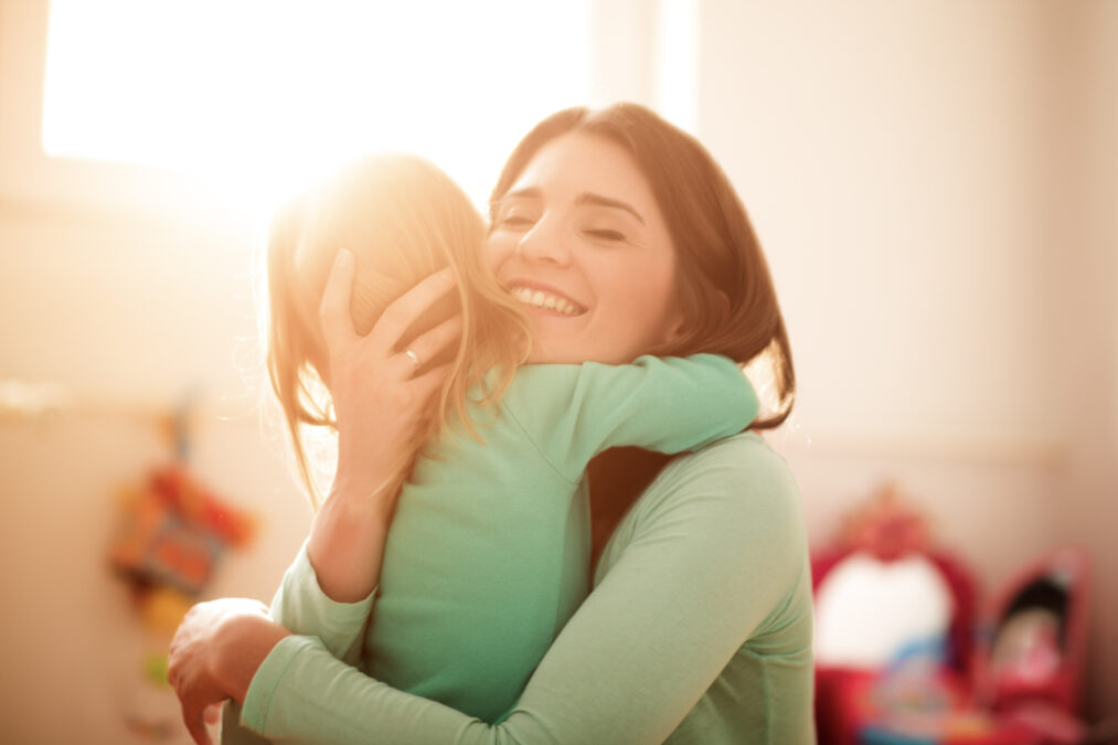 Mother holds her young child, smiling