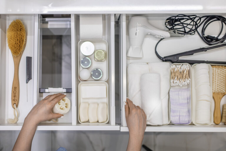 Overhead view of hands organized bathroom items in a drawer