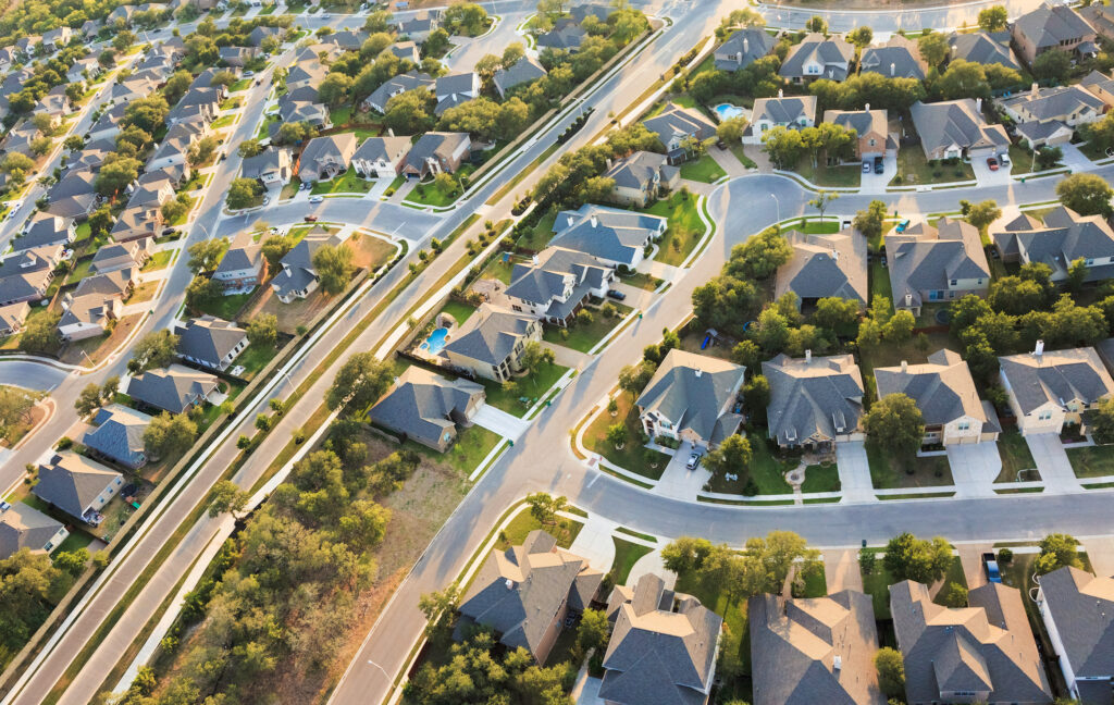 Aerial view of suburban tree-lined street, rooftops