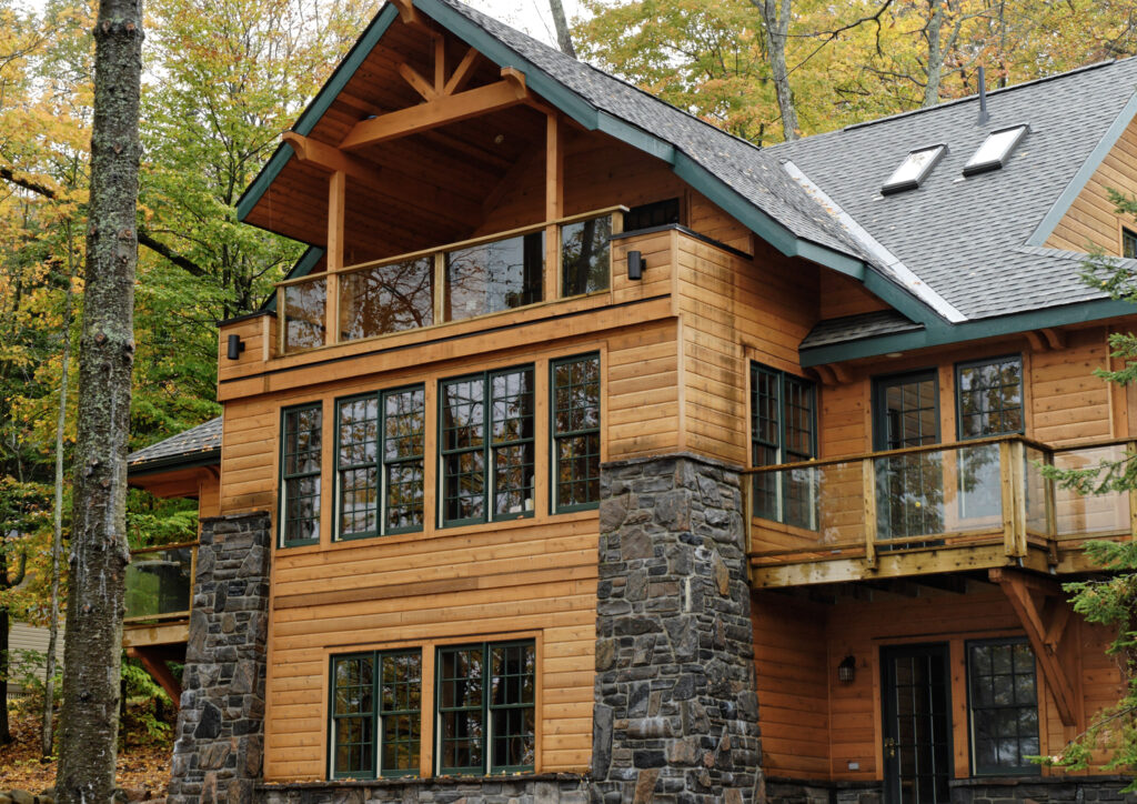 A three-storey cottage with wood cladding in a forest during the fall