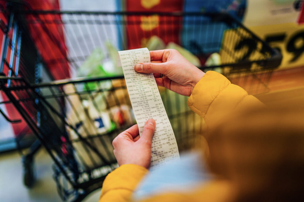 Concerned shopper analyzing expensive grocery bill