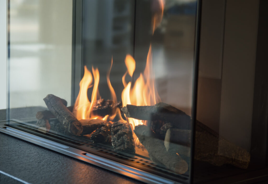 Close up of a modern, lit fireplace with a glass enclosure