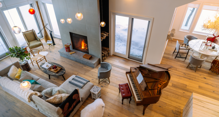 An aerial image of a living room with a lit fireplace and an L-shaped sofa