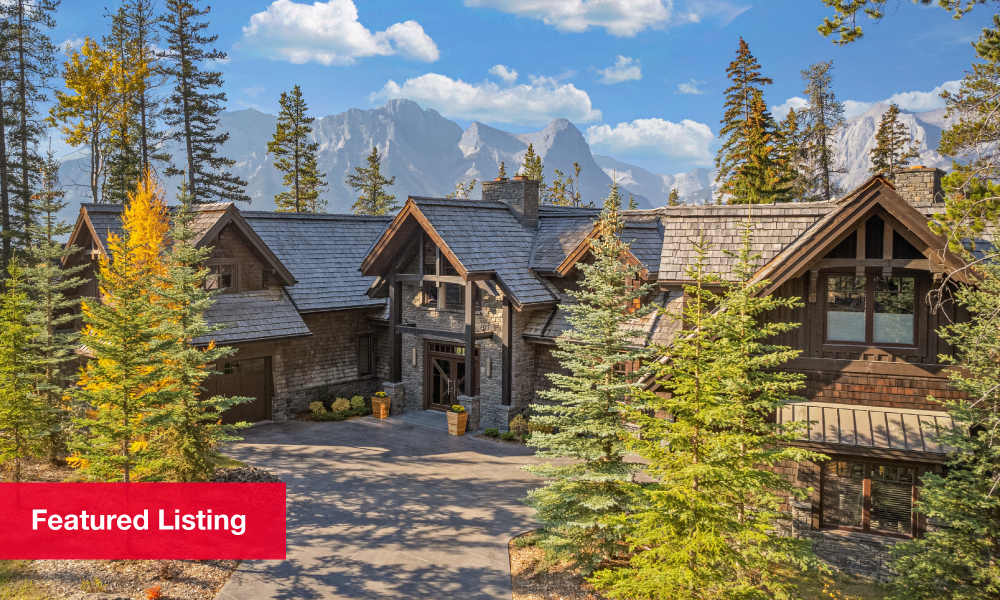 A two-storey stone home during the late fall overlooking the Rocky Mountains