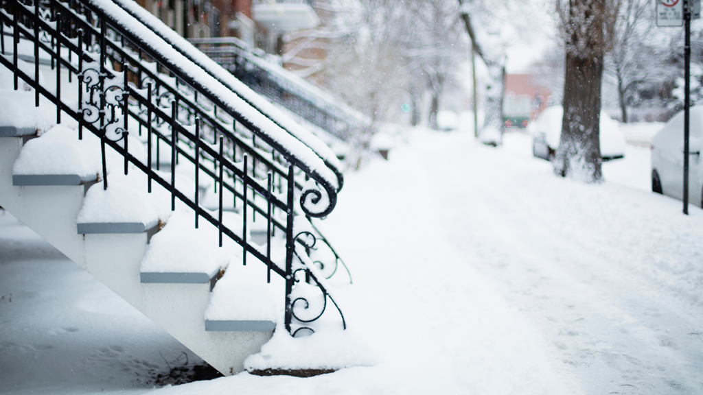 Close up of a set of outdoor stairs with iron railings in Montreal on a snowy day