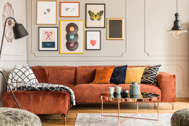 A modern living room with a red velvet sofa and a gallery picture wall
