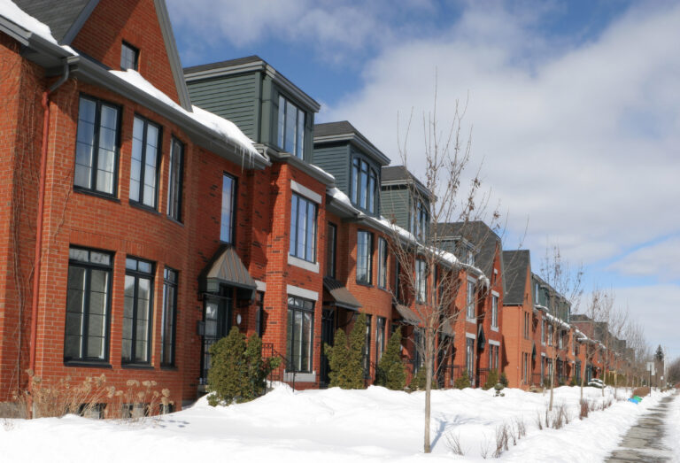 A row of red brick townhomes in the winter during the daytime