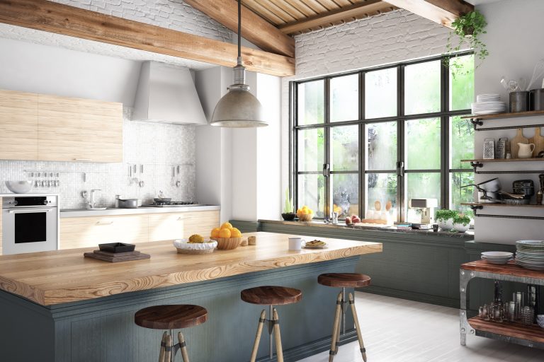 A rustic kitchen with beamed ceilings and a large picture window during the day