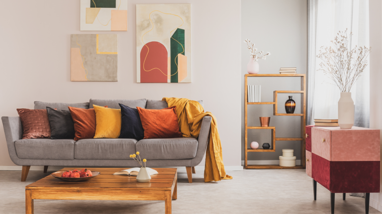 A grey sofa in a living room with colourful pillows