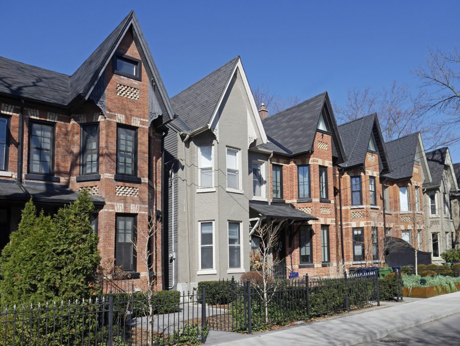 Street with row of narrow brick houses with gables