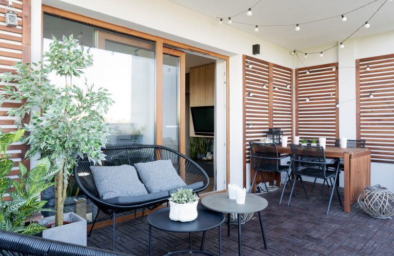 A modern patio with outdoor sofa and dining area