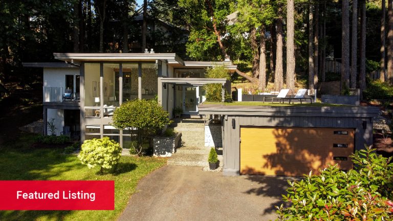 A mid-century modern home during the day surrounded by trees