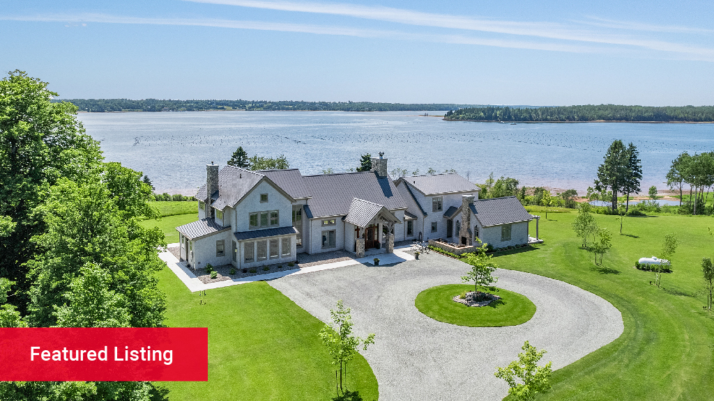 A large modern home overlooking the waterfront during the day