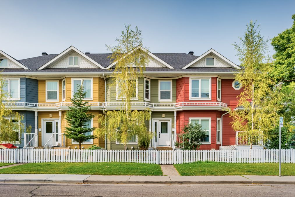 A row of colourful townhomes during the daytime
