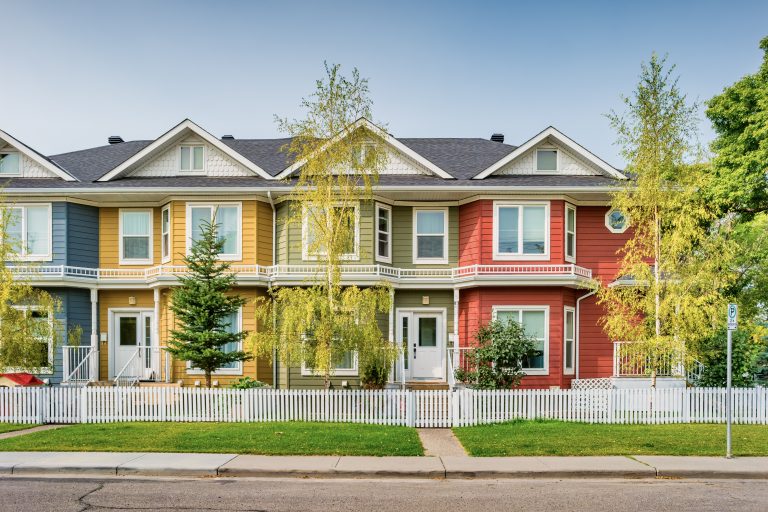 A row of colourful townhomes during the daytime