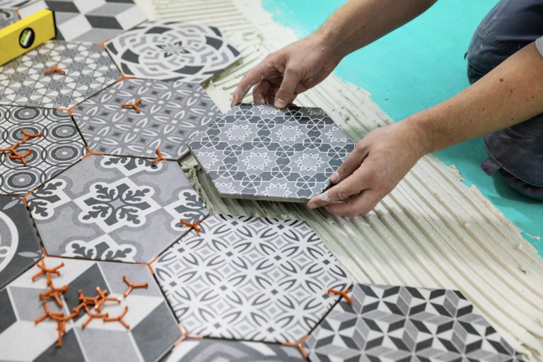 Man laying hexagon tiles on the floor