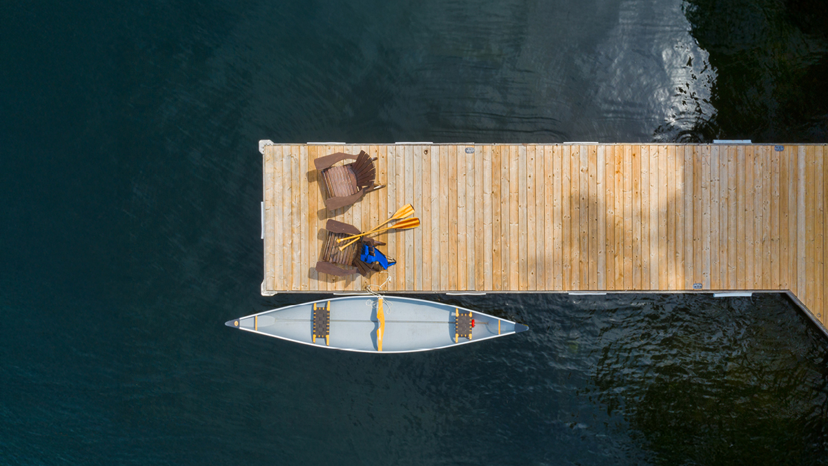 Aerial shot of a canoe in the water attached to a dock