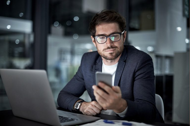 Man in professional suit looks a cellphone