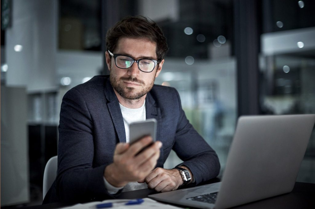 Man in professional suit looks a cellphone