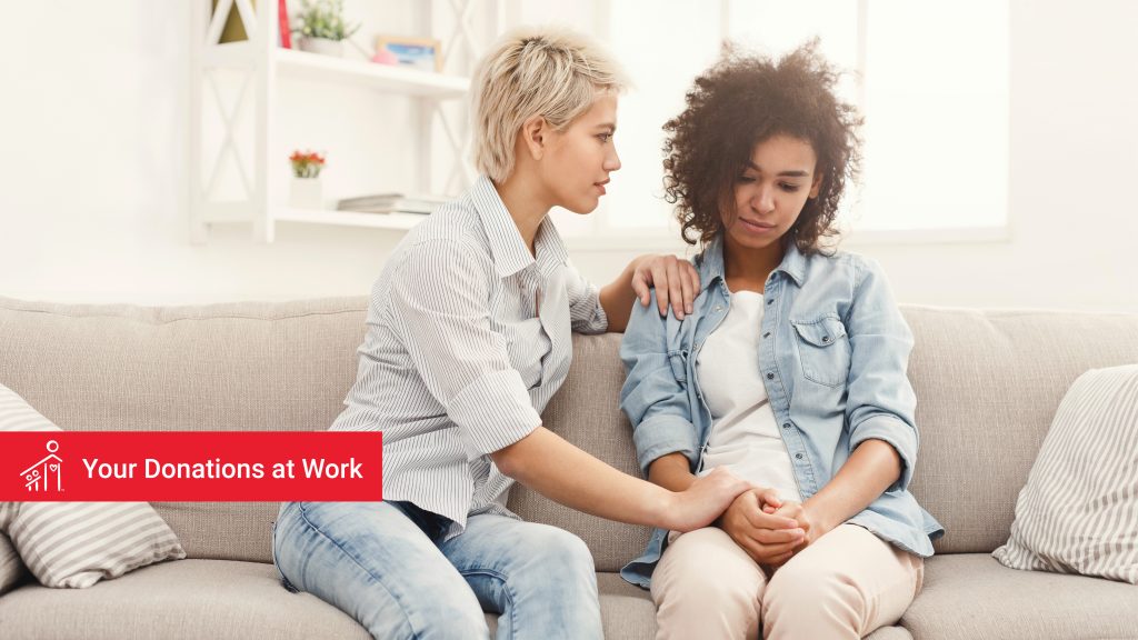 Two women sitting on sofa in living room