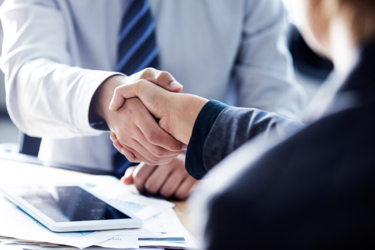 Two people in business attire shake hands