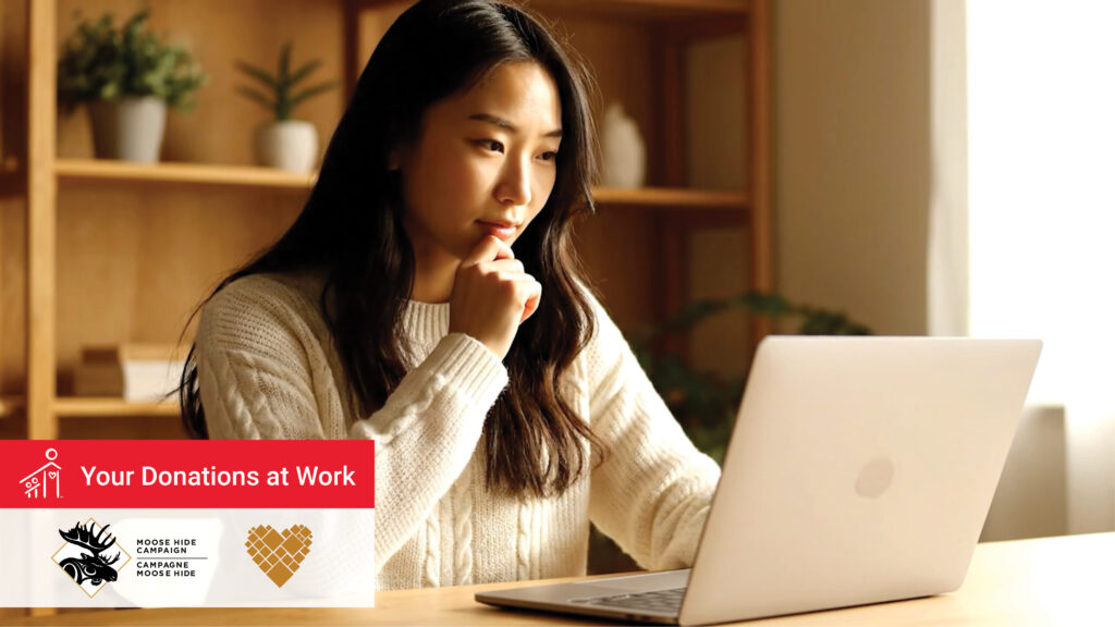 Indigenous woman looks at laptop
