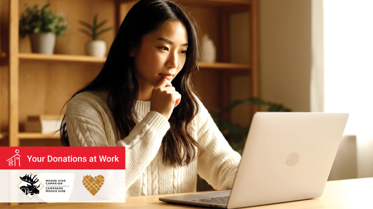 Indigenous woman looks at laptop
