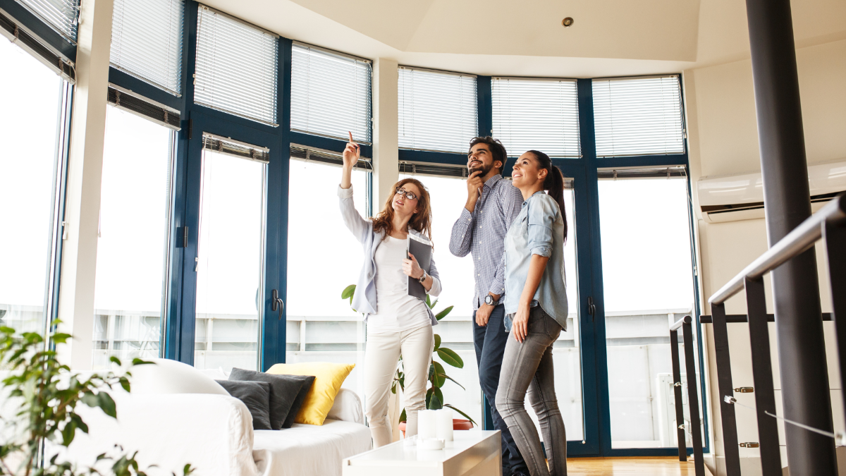 A young couple viewing home with female realtor