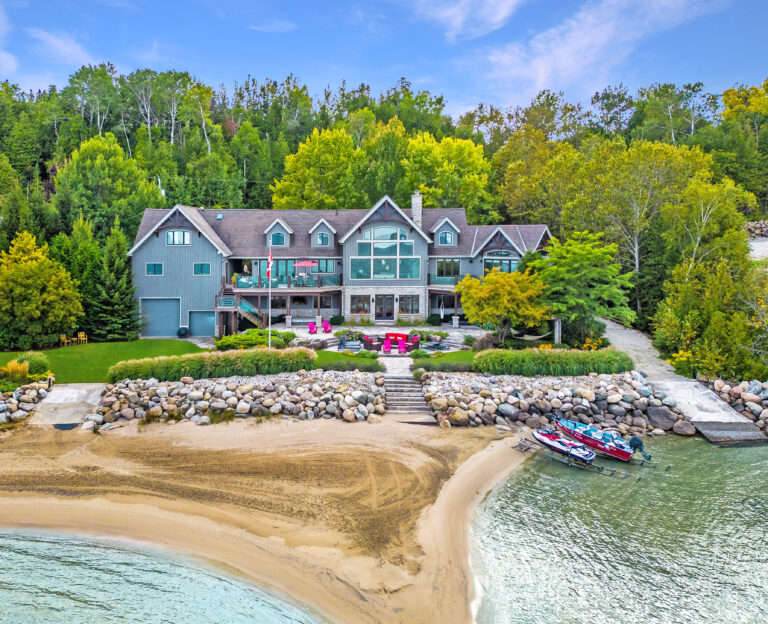 Large luxury recreational home overlooking lake and beach during the day