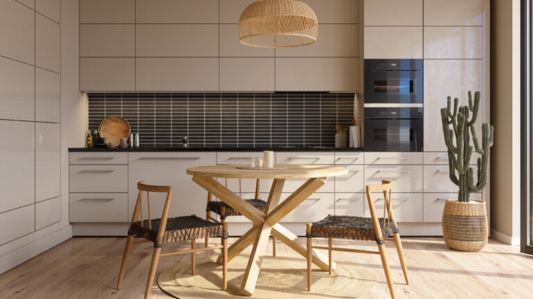 Modern kitchen interior with beige cabinets, wood dining table, chairs and cactus plant