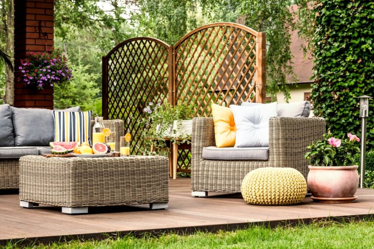Grapefruit and orange juice on table on wooden terrace with yellow pouf next to armchair