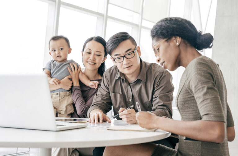 A young family with baby consulting with mortgage broker at table
