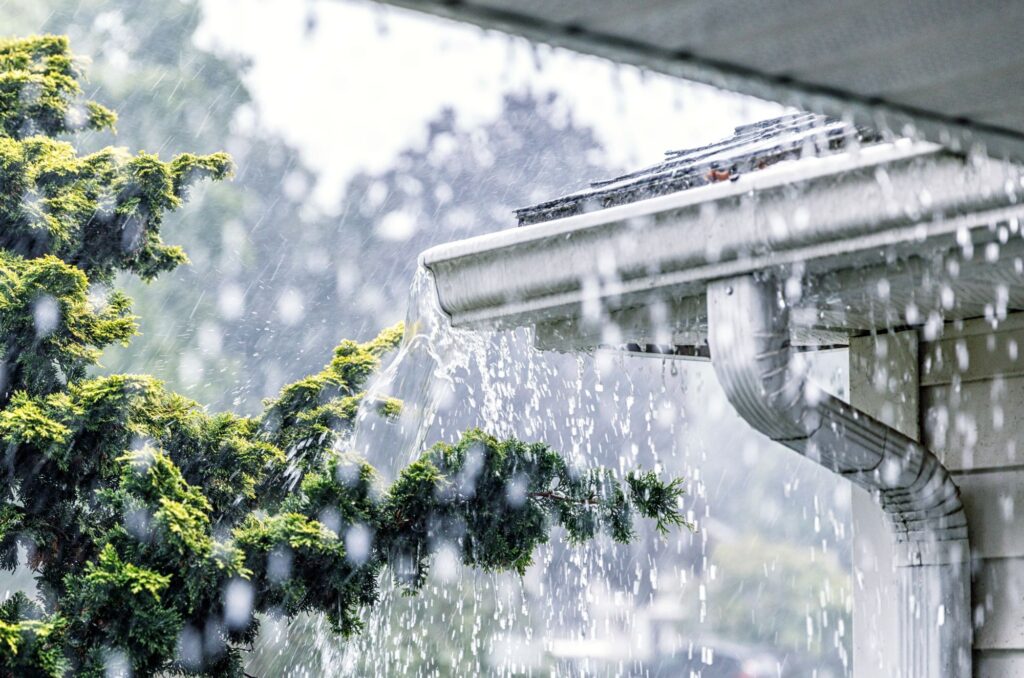 Eavestroughs overflowing with rainwater on residential property