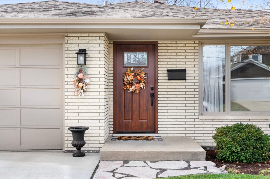Wooden front door with wreath on a well-maintained home exterior with clean walkway