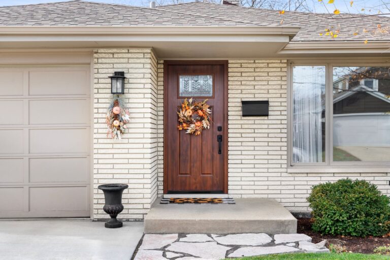 Wooden front door with wreath on a well-maintained home exterior with clean walkway
