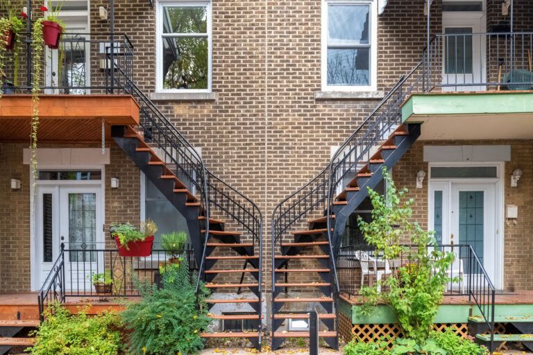 Classic Quebec duplex on a residential street with exterior staircases and balconies